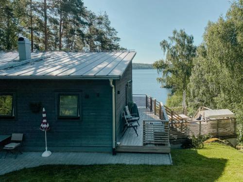 a house with a deck and a view of the water at Modern Glass House With A View Over Lake Lejondal in Bro