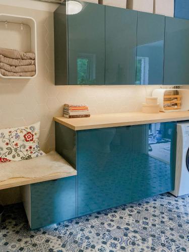 a bathroom with blue cabinets and a sink at Modern Glass House With A View Over Lake Lejondal in Bro