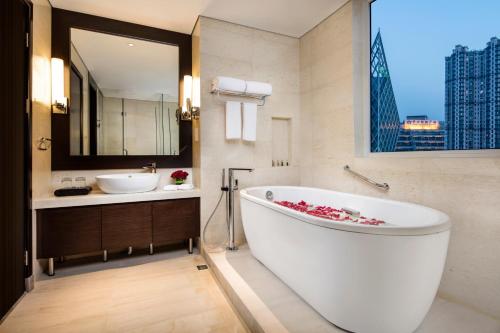 a bathroom with a large tub and a sink at Ascott TEDA MSD Tianjin in Binhai