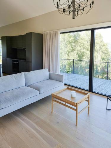 a living room with a couch and a table at Cabin By The Fjord With Rooftop Terrace On Randøy in Hjelmeland