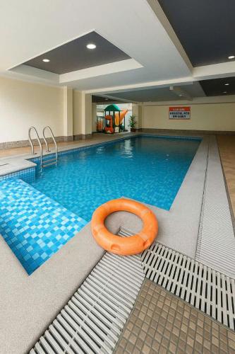 a large swimming pool with an orange raft in the middle at Close by the airports and tourist attractions in Manila