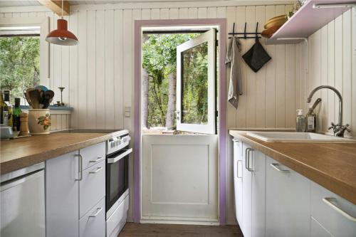a kitchen with white cabinets and a sink and a window at Forest Vibe And Idyll On Møn in Stege
