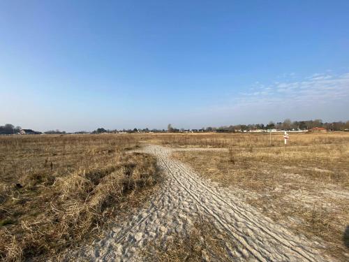 a dirt road in the middle of a field at Beach House With Sauna By Norsminde Harbour in Malling
