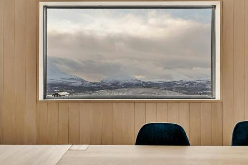 a large window in a room with a table and chairs at Modern Cabin In Harmony With Nature in Moen i Målselv