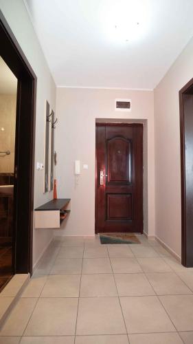 a hallway with a wooden door and a tile floor at Flat Lora Pomorie in Pomorie