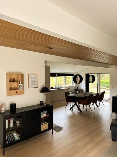 a living room with a table and chairs in it at New Summer House In Fuglslev With Wilderness Bath in Ebeltoft