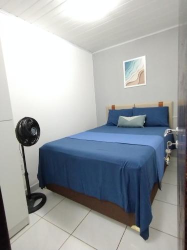 a bedroom with a blue bed in a white room at Casa dos Demeries in Triunfo