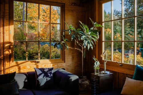 a living room with a couch and large windows at Restored Quarry House Near Nobel Laureate Home in Lönsboda