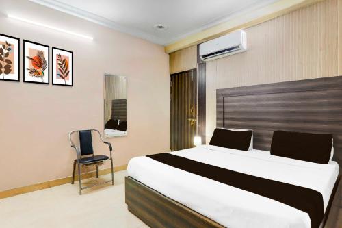 a bedroom with a large bed and a chair at Collection O Sharda Nagar Lucknow in Lucknow