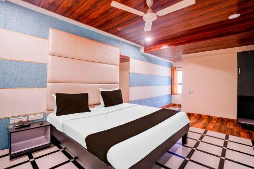 a bedroom with a large bed and a tv at Collection O Palava Dombivali in Mumbai