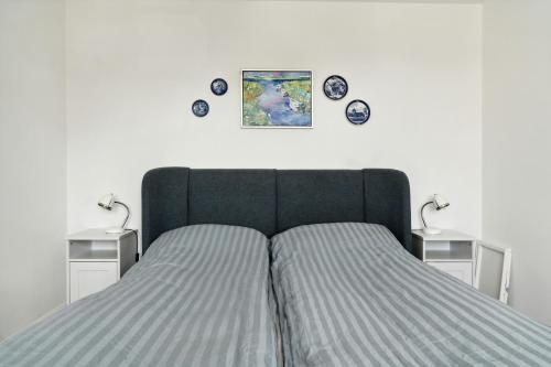 a bedroom with a bed with two tables and plates on the wall at Enjoy Møn From Historic House in Stege