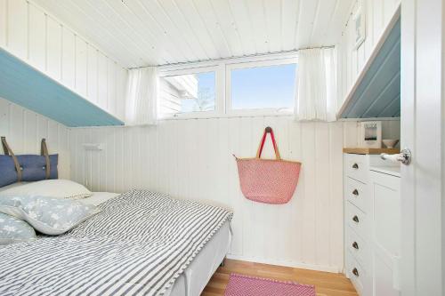 a small bedroom with a bed and a window at Idyllic Holiday Home Charm In Nr, Lyngby in Løkken