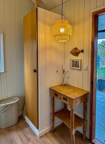 a room with a table and a toilet and a lamp at Idyllic Holiday Home Charm In Nr, Lyngby in Løkken