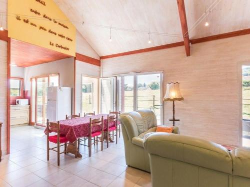 un salon avec un canapé et une table avec des chaises dans l'établissement Gîte écologique calme proche Vosges, accueil PMR - FR-1-583-465, à Frahier-et-Châtebier