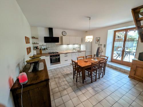 - une cuisine avec une table et des chaises en bois dans la chambre dans l'établissement Gîte calme proche Villersexel, nature et activités - FR-1-583-450, à Esprels
