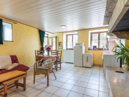 un salon avec une table, des chaises et un réfrigérateur dans l'établissement Gîte confortable de plain-pied à Confracourt, nature et détente - FR-1-583-445, à Confracourt
