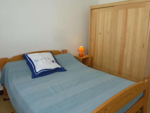 - une chambre avec un lit doté d'une couverture bleue et d'une lampe dans l'établissement Maison de vacances 2 chambres proche plage et forêt - FR-1-246A-361, à Saint-Trojan-les-Bains