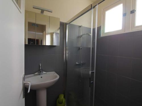 La salle de bains est pourvue d'un lavabo et d'une douche. dans l'établissement Maison de vacances 2 chambres proche plage et forêt - FR-1-246A-361, à Saint-Trojan-les-Bains