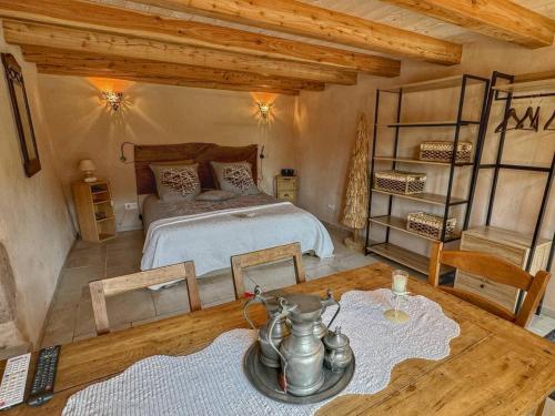 a bedroom with a large bed and a table at Gîte du Bois des Hauts : Confort en pleine nature, proche Plateau des 1000 Étangs - FR-1-583-439 in La Lanterne-et-les-Armonts