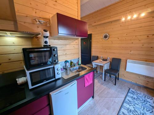 une cuisine avec un évier et un plan de travail dans l'établissement Chalet détente avec spa et sauna près des 1000 Étangs - FR-1-583-468, à La Vaivre