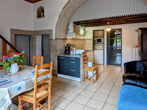 une cuisine et un salon avec une table et des chaises dans l'établissement Gîte de charme à Saint-Bresson, proche activités nature - FR-1-583-476, à Saint-Bresson