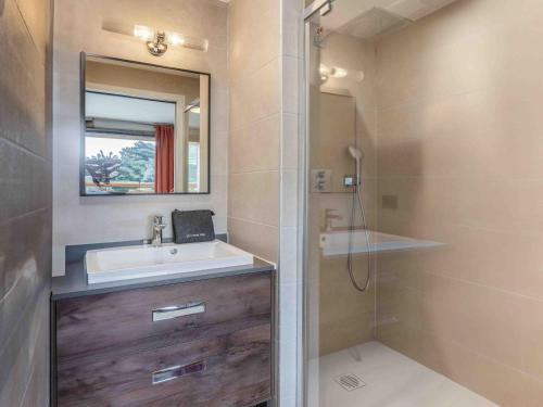 une salle de bain avec un lavabo, un miroir et une douche dans l'établissement Appartement spacieux, ski au pied, parking inclus - FR-1-565-129, à Les Allues