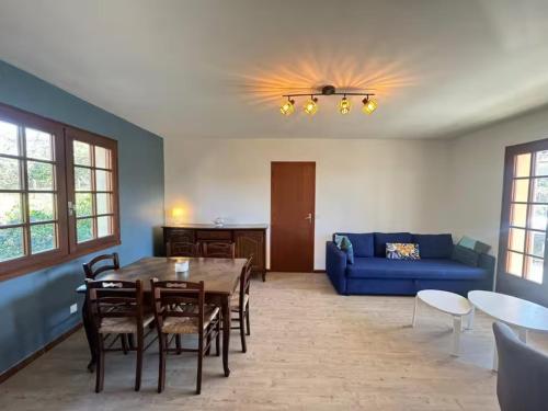 un salon avec une table et un canapé bleu dans l'établissement Maison familiale 6 pers à 200m de la plage - FR-1-239-1133, à Capbreton