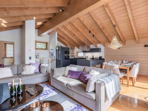 un salon avec deux canapés et une cuisine dans l'établissement Chalet chic avec jacuzzi et sauna à Méribel - FR-1-565-131, à Les Allues