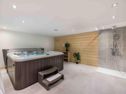 une grande salle de bain avec baignoire et douche dans l'établissement Chalet chic avec jacuzzi et sauna à Méribel - FR-1-565-131, à Les Allues