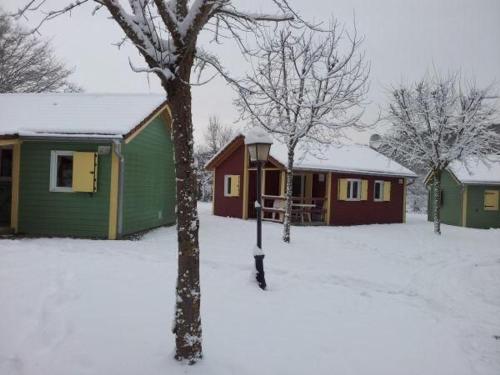un groupe de maisons avec de la neige au sol dans l'établissement Chalet Édelweiss 35 en lisière de forêt, calme et nature - FR-1-583-444, à Mélisey
