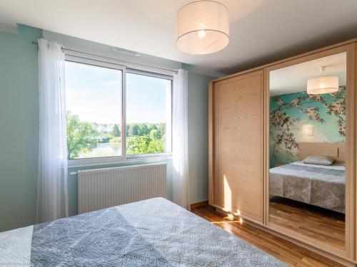 una camera da letto con un letto e una grande finestra di Maison rénovée au bord de la Saône avec terrasse et jardin - FR-1-583-463 a Rigny