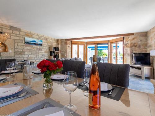 a dining room with a table with a bottle of wine at Confort moderne dans les Vosges du Sud avec piscine et jacuzzi - FR-1-583-480 in Villers-lès-Luxeuil