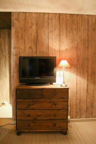 a television sitting on top of a dresser with a lamp at Charming Cabin In Vikerfjell in Hønefoss