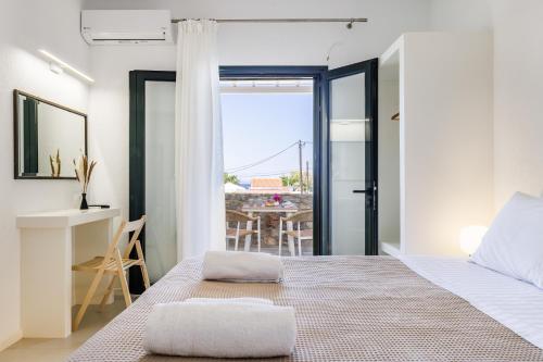 a bedroom with a bed and a desk and a table at Lithanemon in Agnontas