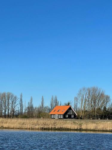 a house with an orange roof next to the water at House With Great Sea View On Lilleø in Askø By