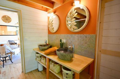 La salle de bains est pourvue de 2 lavabos et de 2 miroirs sur le mur. dans l'établissement Lodge At The Foot Of Dentelles De Montmirail, à Lafare