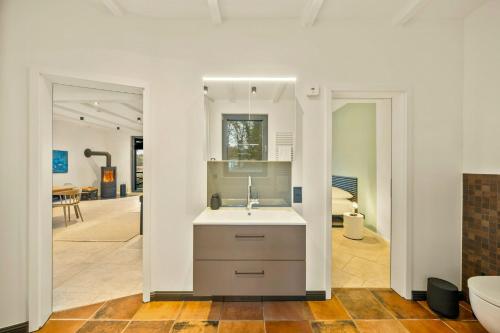 a kitchen with a sink and a counter top at Cozy Wooden House By The Lake in Falkensee
