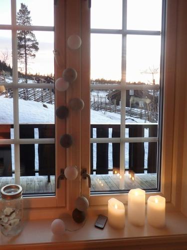 a window with candles on a window sill with a view at Mountain Cabin With Views Over Nesfjellet in Nesbyen