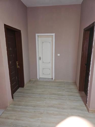 ein leeres Zimmer mit einer weißen Tür und Fliesenboden in der Unterkunft Entire Duplex in Sirakoro in Bamako