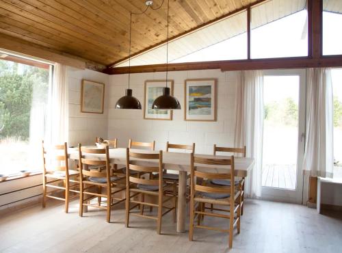 ein Esszimmer mit Tisch und Stühlen in der Unterkunft Dune House Near Bulbjerg in Frøstrup