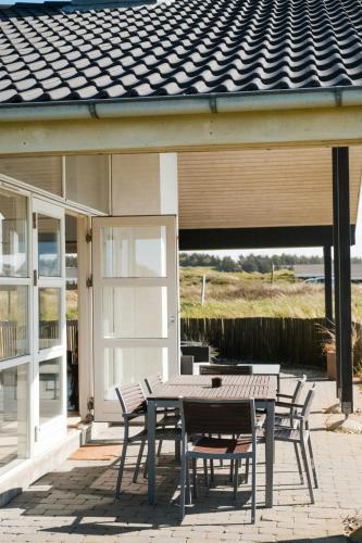 a table and chairs on the patio of a house at West Jutland In Peaceful Havblik Setting in Nørlev