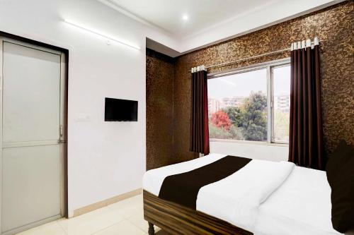 a bedroom with a bed and a large window at Collection O Jagatpura Near JTM Mall in Jaipur