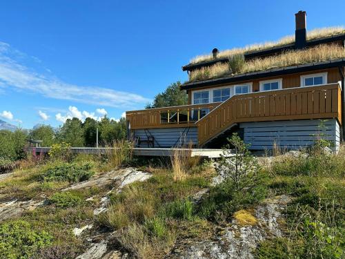 a house with a grass roof on top of a hill at Seaside Cabin With Fjord Views In Skjerstad in Skjerstad