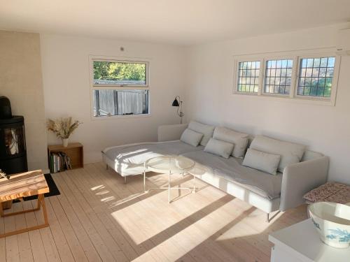 a living room with a couch and a table at Charming Cottage Close To Smidstrup Beach in Gilleleje