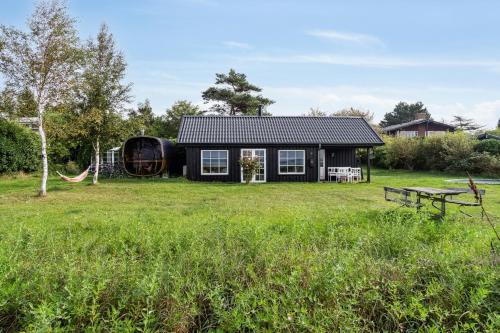 a house in a field with a picnic table at Island Life Gem With All Heart Desires in Kragenæs