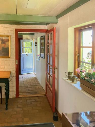 a hallway with a blue door and a table at Peaceful Summer House Near Ulvemosehule Forest in Glamsbjerg