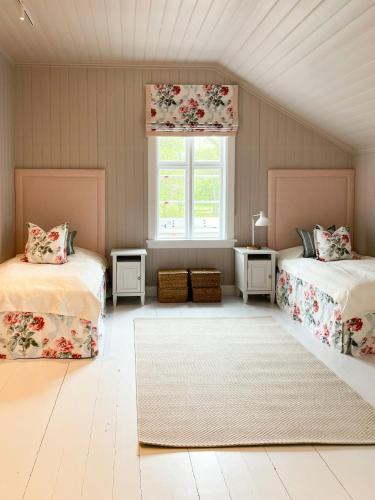 a attic bedroom with two beds and a window at Charming Swiss-Style Cabin On Hankø in Gressvik