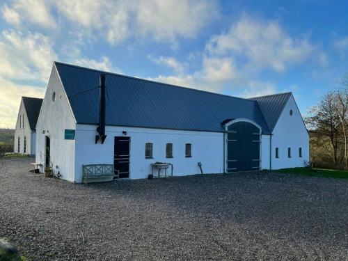 a large white barn with a black roof at Apartment With Lovely Views In Veddinge Bakker in Fårevejle