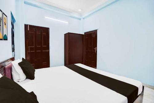 a bedroom with two beds and two doors at Collection O Garden View Vrindavan Lucknow in Lucknow