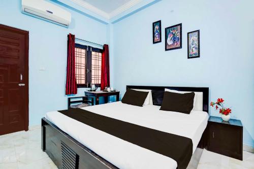 a bedroom with a large bed in a blue room at Collection O Garden View Vrindavan Lucknow in Lucknow